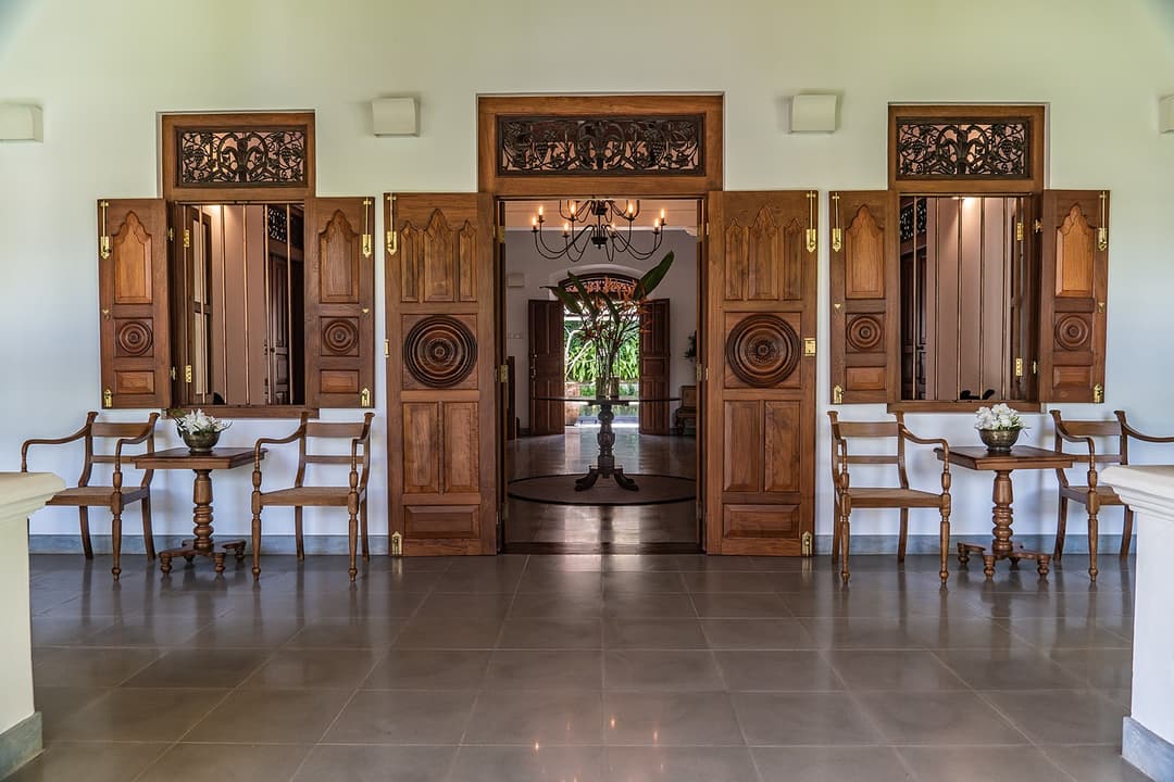 Ornate carved double entrance doors opening to dining hall at Island Villa Ahangama