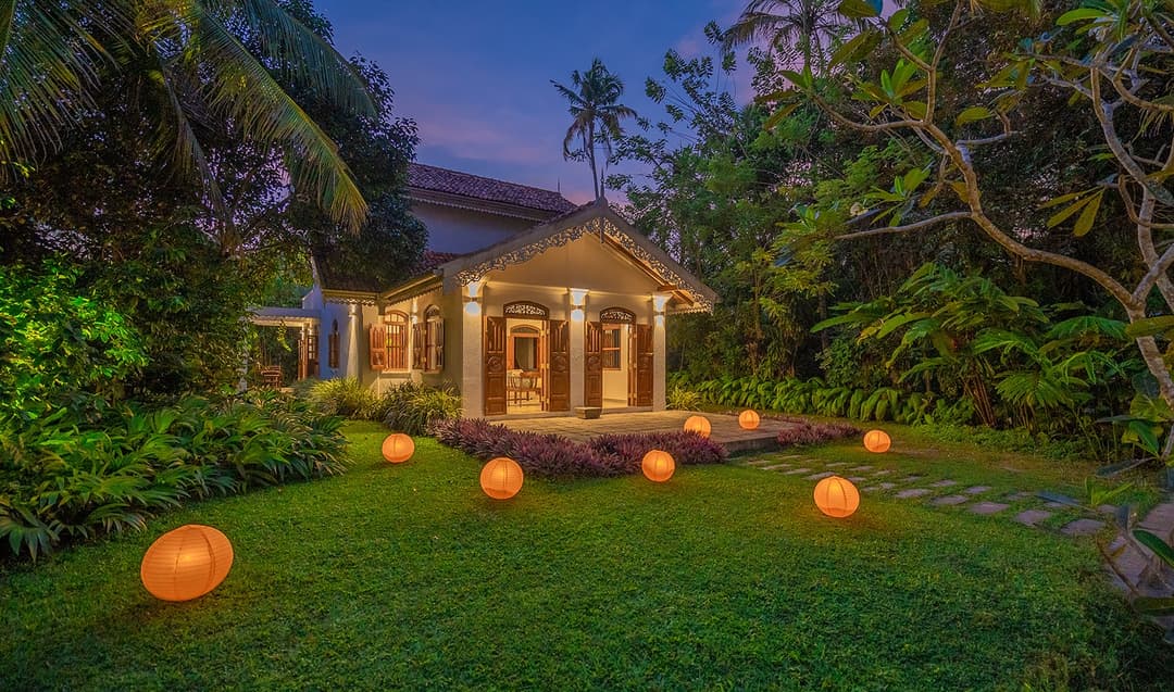 Main house illuminated at dusk with lit lawns at Island Villa Ahangama, Ahangama, Sri Lanka