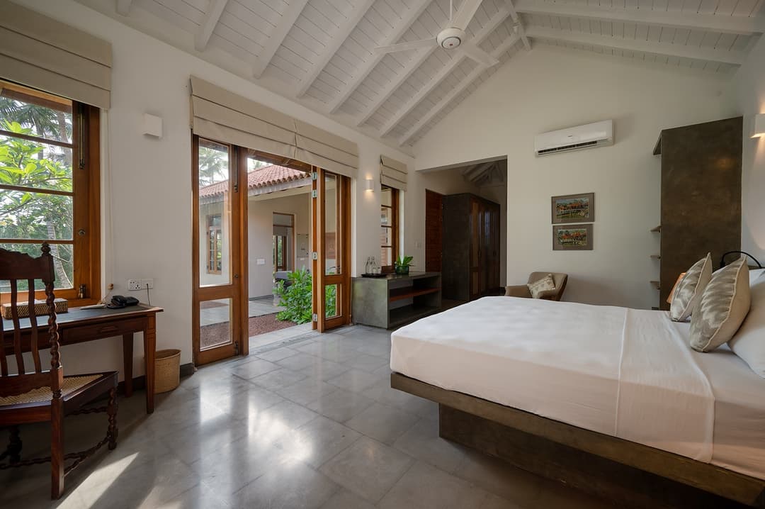 King bedroom with doors fully open to tropical garden at Kirana Villa, Bentota