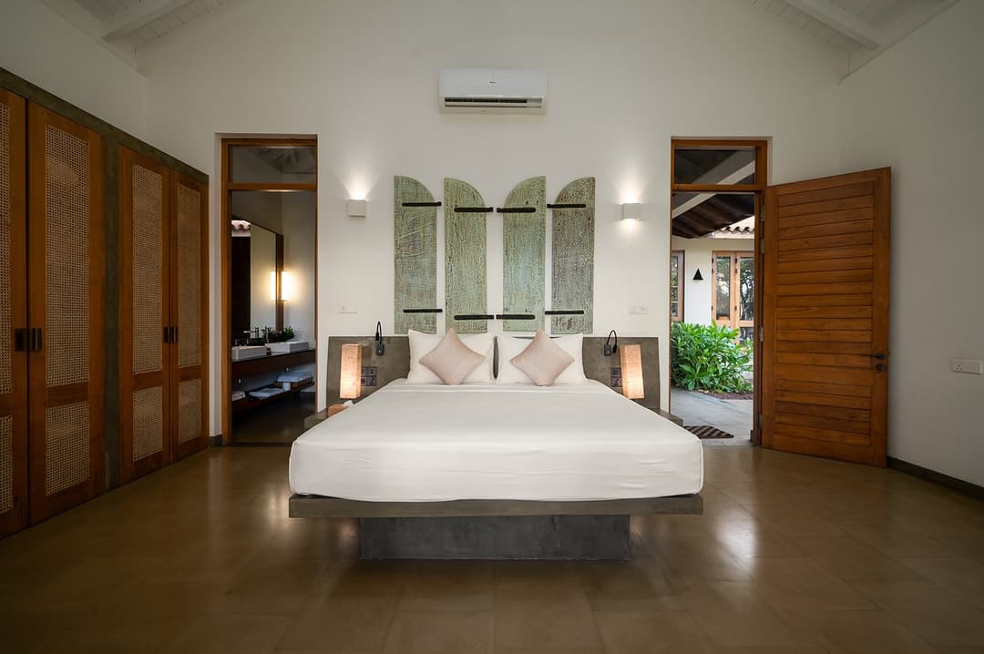Bedroom with king bed, teal blue accents and garden windows at Kirana Villa, Bentota
