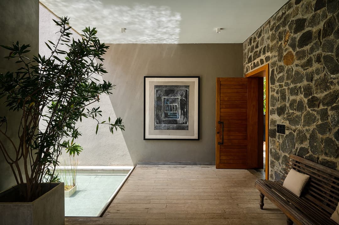 Entrance corridor with stone wall and artwork at Kirana Villa, Bentota, Sri Lanka