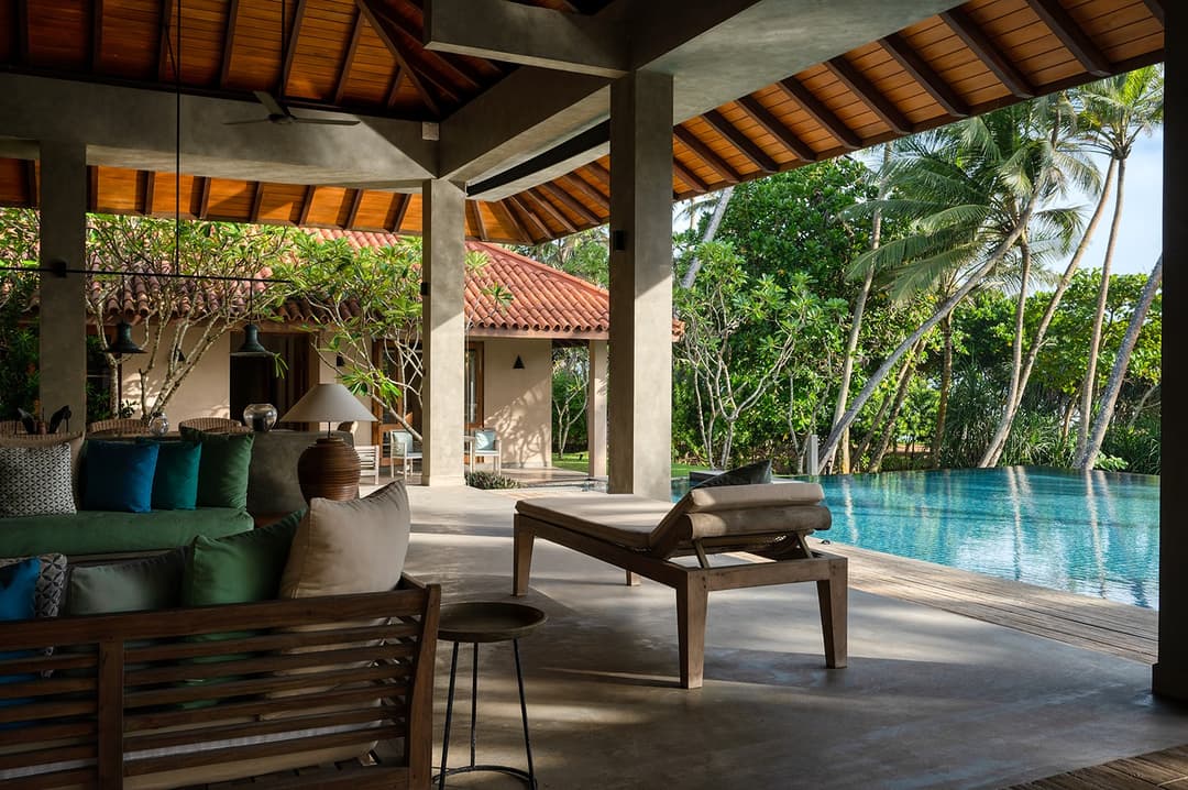 Living pavilion terrace with teal cushions, pool and palms at Kirana Villa, Bentota