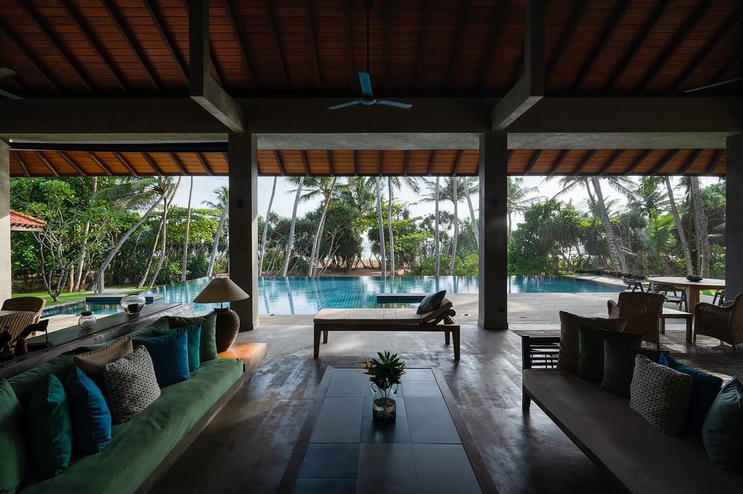 Wide open living pavilion with teal cushions and garden beyond at Kirana Villa, Bentota
