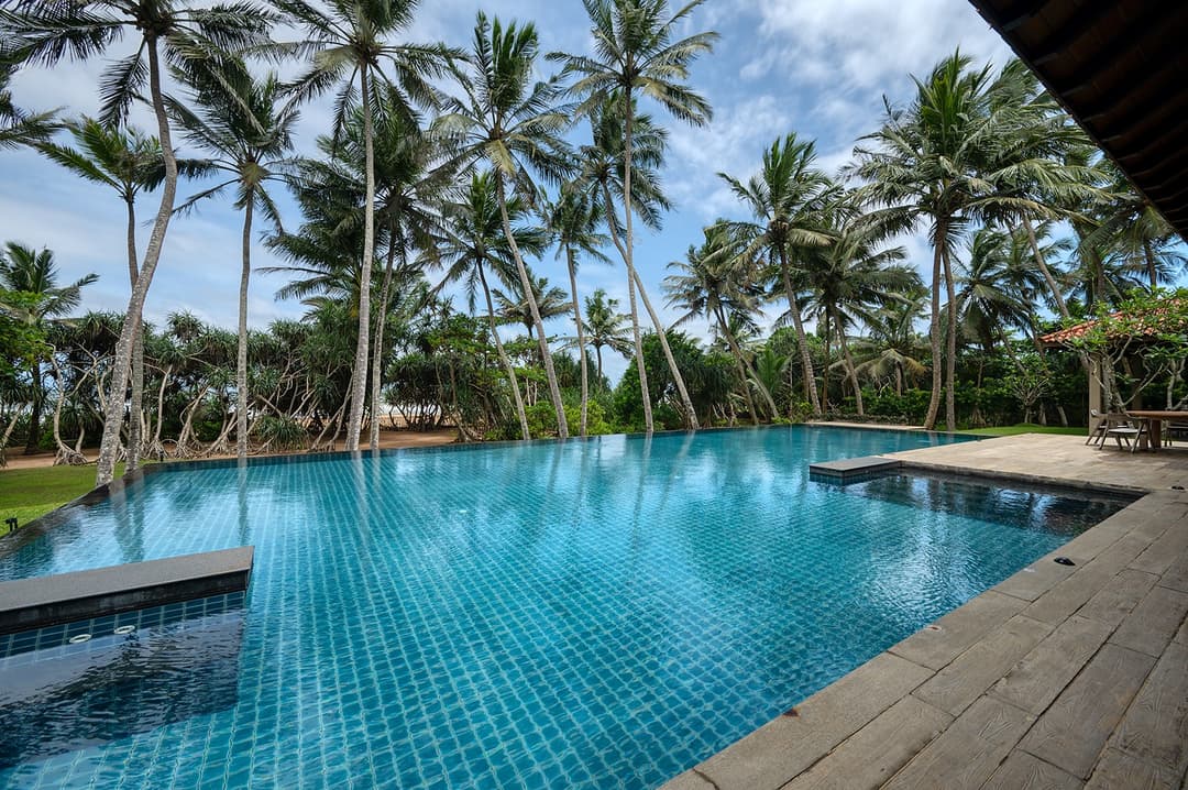Kirana Villa Bentota 20-metre infinity pool with coconut palms and beach beyond