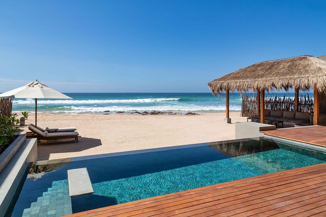 Wide daytime view of The Six Weligama pool with pavilion and beach, Midigama, Sri Lanka