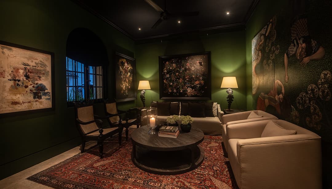 Green-walled lounge with small dining table and artwork, No. 77 Leyn Baan, Galle Fort