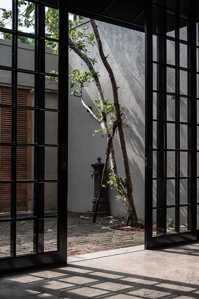 Arched entrance gate open to courtyard with plants, No. 77 Leyn Baan, Galle Fort, Sri Lanka