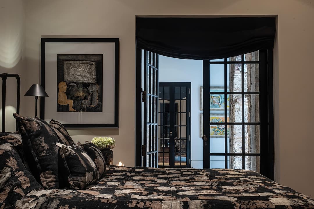 Bedroom with dark patterned bedding and steel frame window, No. 77 Leyn Baan, Galle Fort