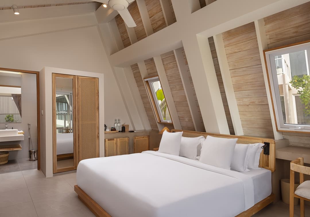 Asaya Sands Mirissa A-frame bedroom with king bed and vaulted ceiling, pool view beyond
