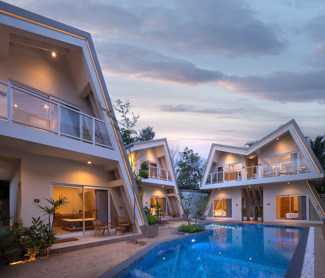Asaya Sands Mirissa exterior at dusk with lit A-frame chalets and pool, Mirissa, Sri Lanka
