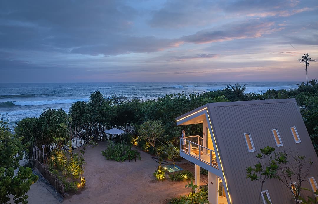 Wide dusk view of Asaya Sands Mirissa pool, chalets and ocean beyond, Mirissa, Sri Lanka