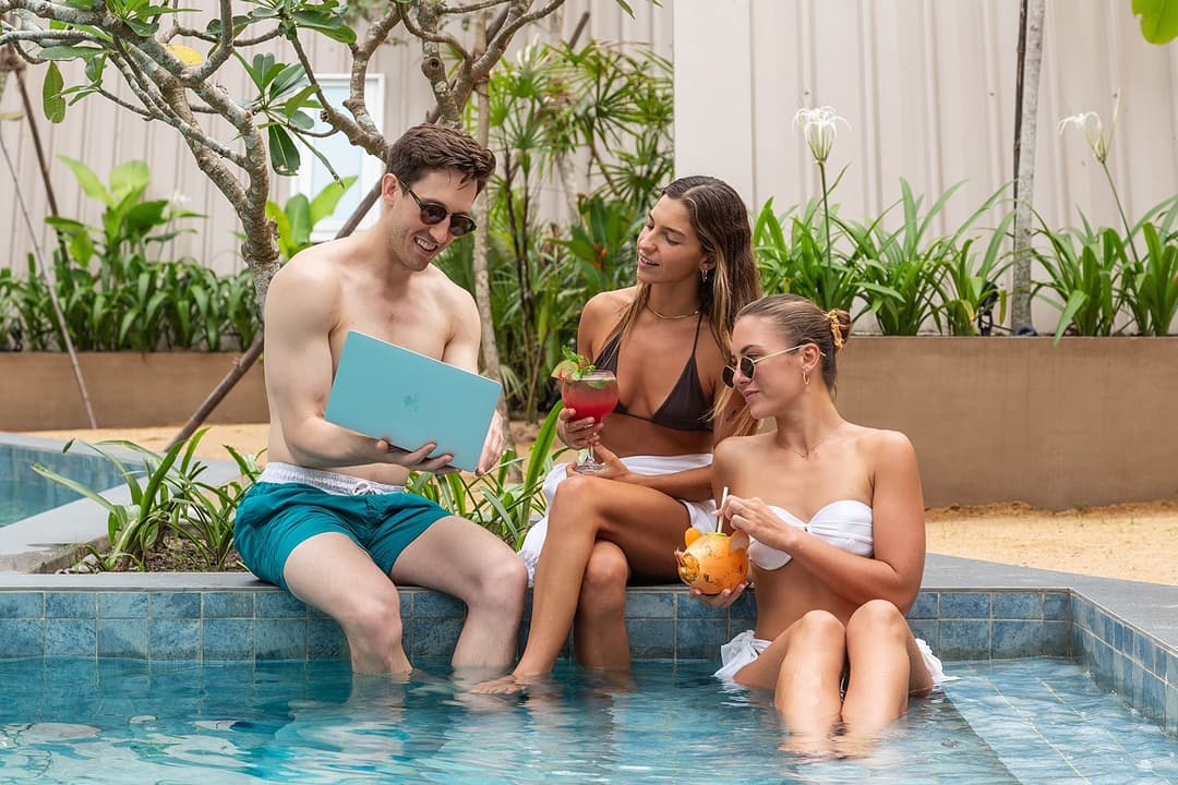 Three guests at pool edge with feet in water at Asaya Sands, Mirissa, Sri Lanka
