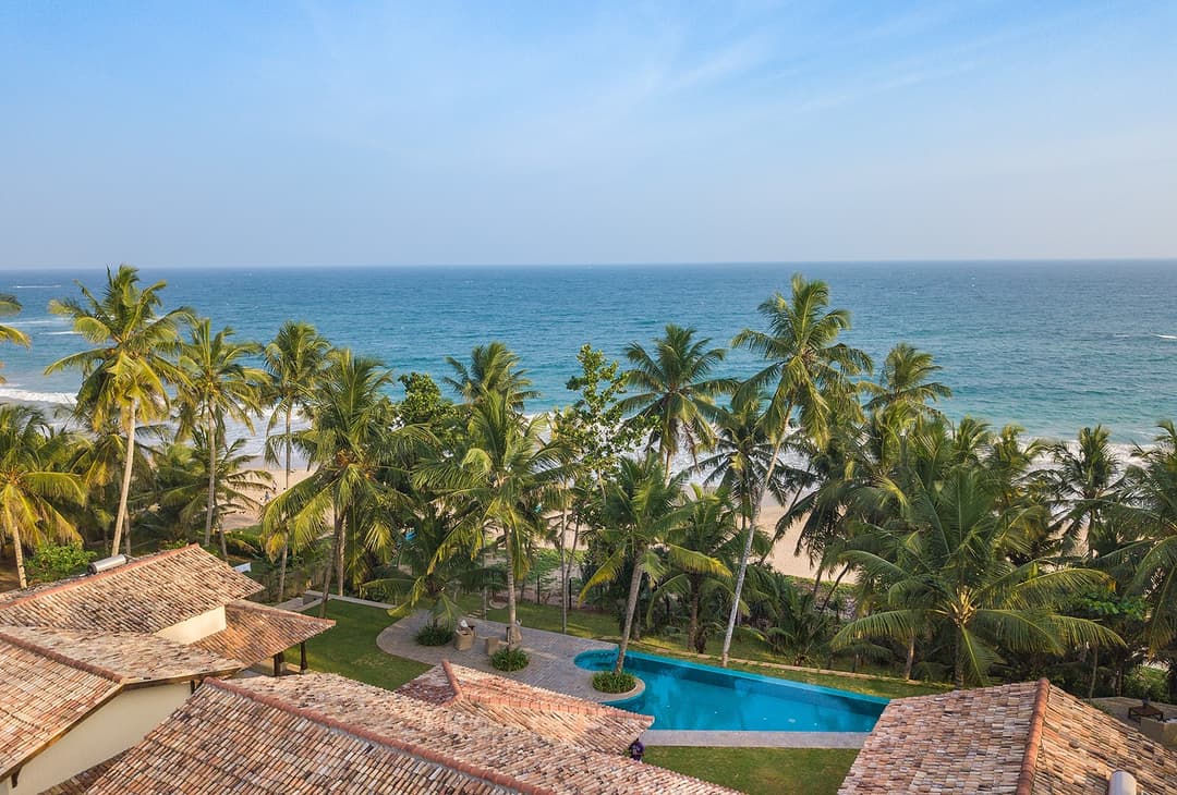 Aerial of Abiman Dickwella villa and pool from front with beach, Dickwella, Sri Lanka