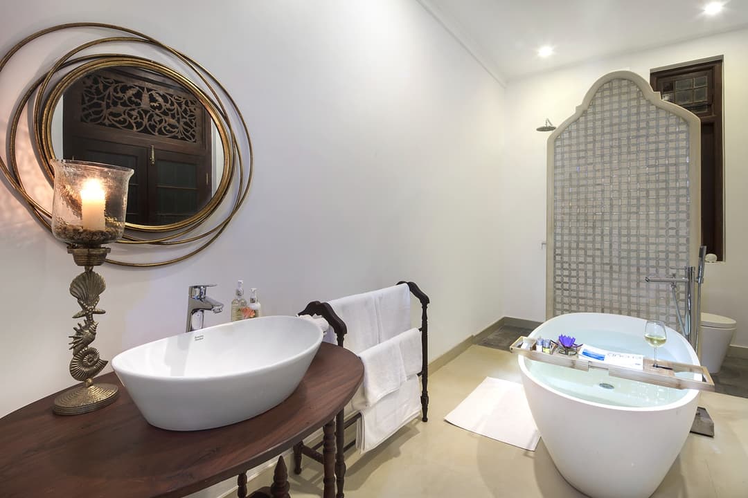 Bathroom with freestanding bathtub and round mirror at Abiman, Dickwella, Sri Lanka