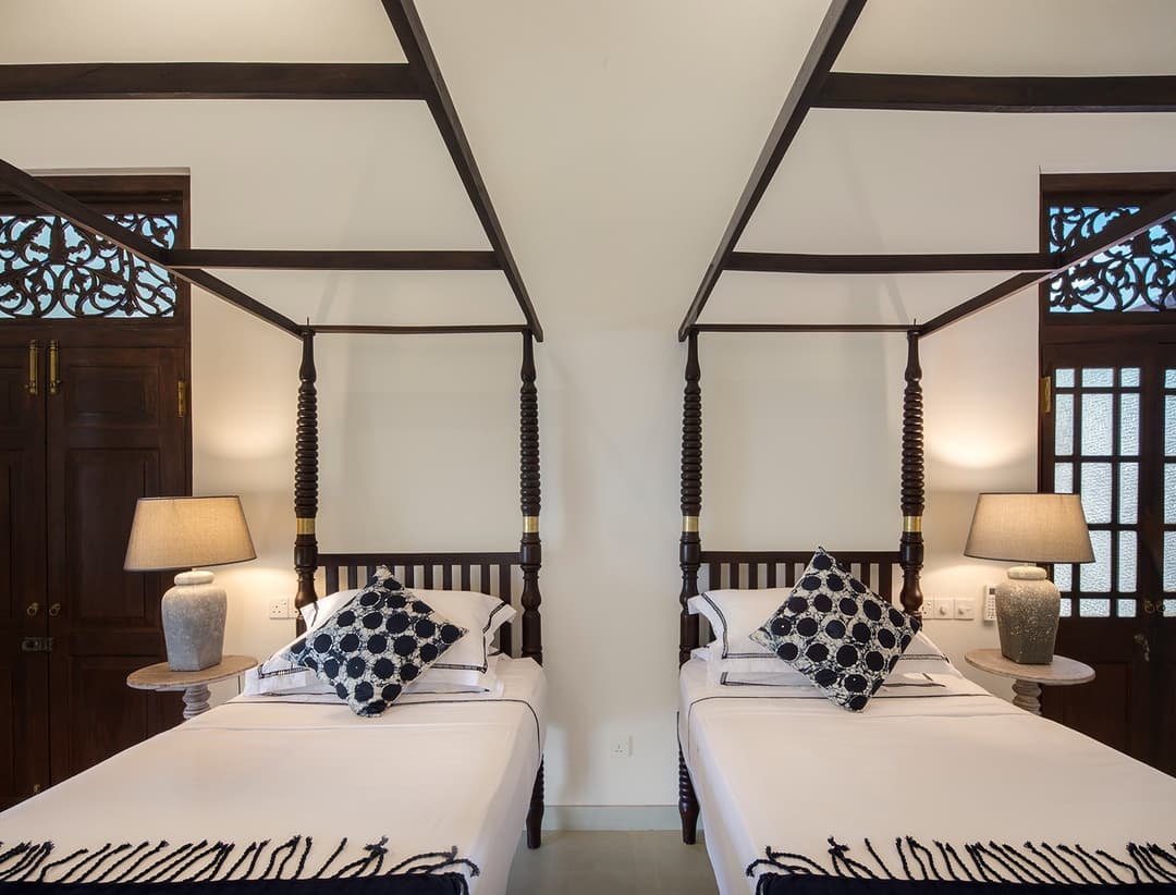Four-poster bedroom with dark decorative screen headboard at Abiman, Dickwella