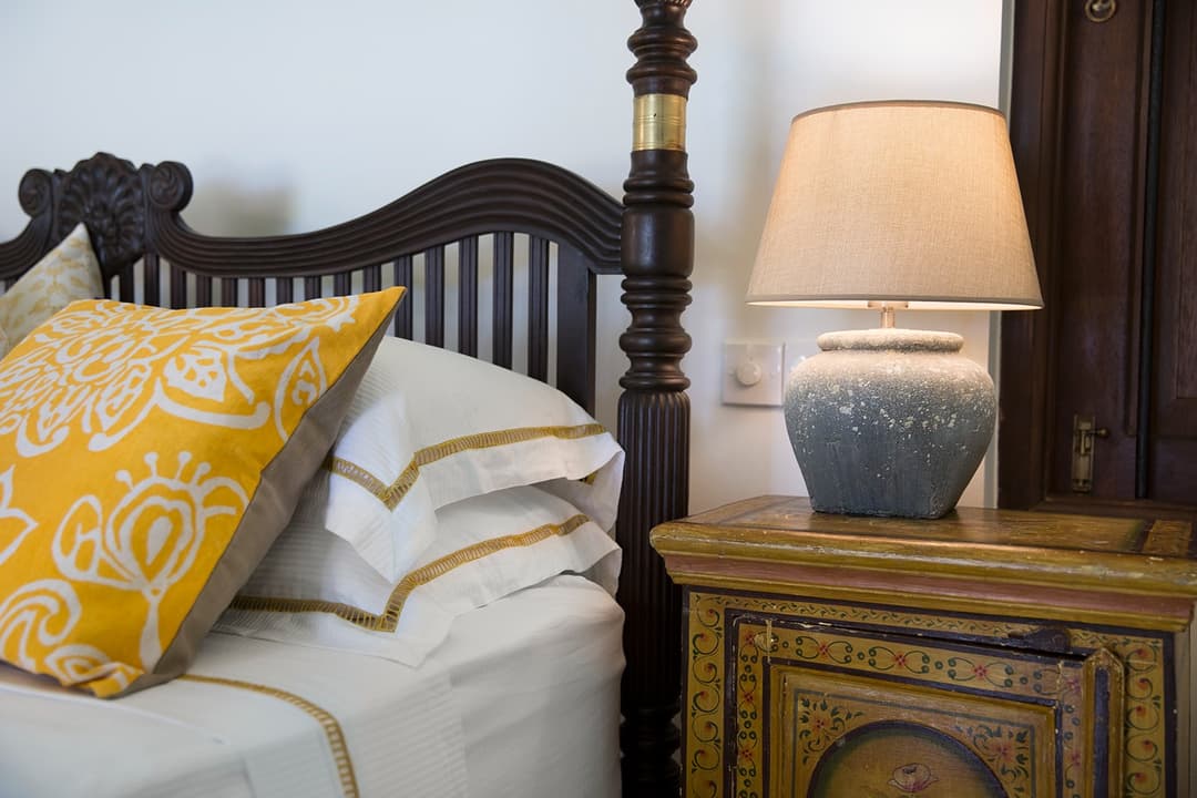 Bedroom four-poster headboard with yellow cushion detail at Abiman, Dickwella