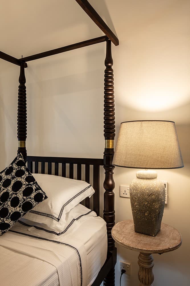 Four-poster king bedroom with blue bedding accents at Abiman, Dickwella, Sri Lanka