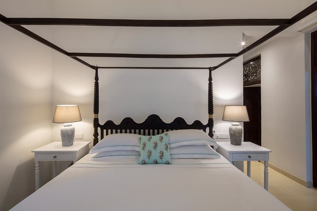 Four-poster king bedroom with minimal neutral tones at Abiman, Dickwella, Sri Lanka