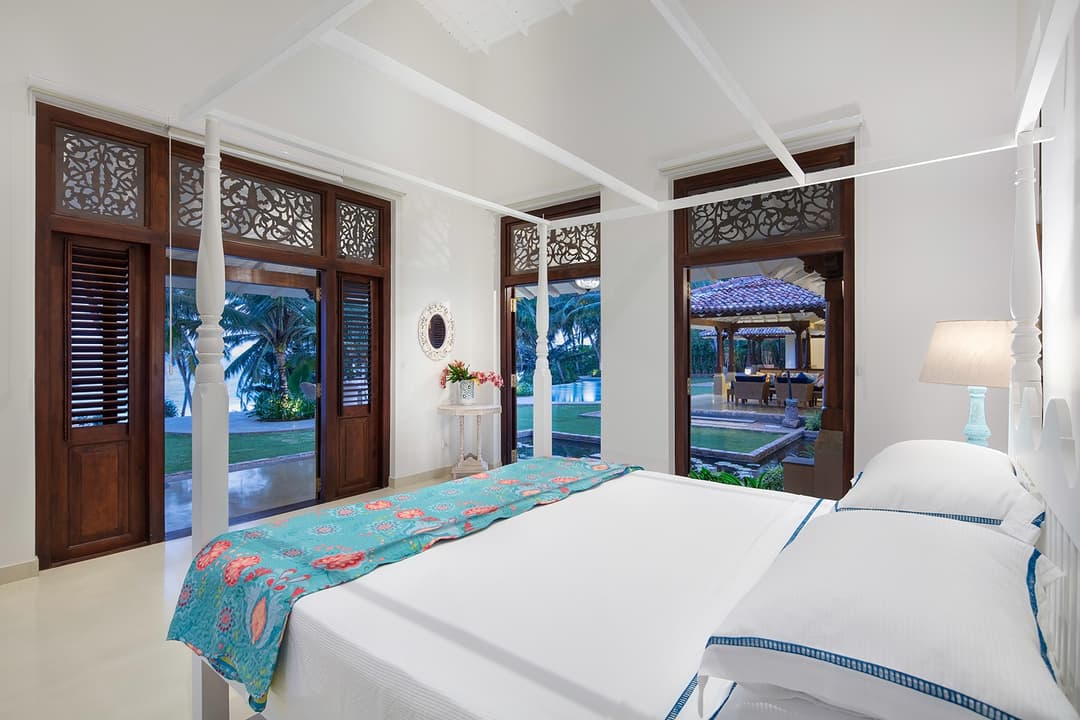 Bedroom with twin beds and teal accents open to garden at Abiman, Dickwella, Sri Lanka