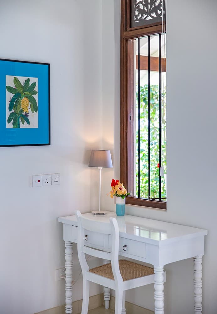 Bedroom with writing desk, blue painting and louvred window at Abiman, Dickwella