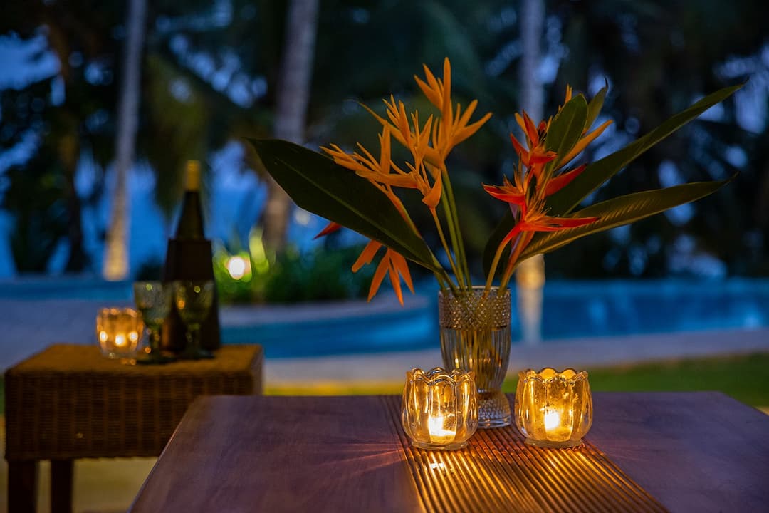 Outdoor dining at dusk with candles and flowers at Abiman, Dickwella, Sri Lanka
