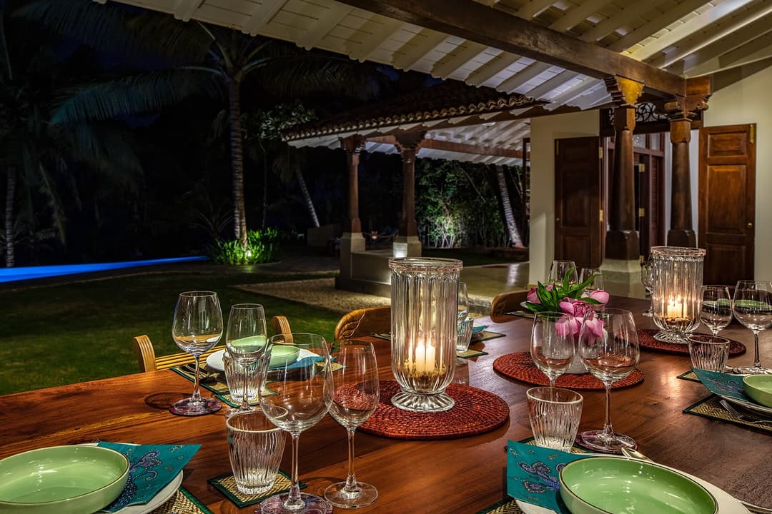 Outdoor dining at night with candles and colourful tableware, Abiman Dickwella