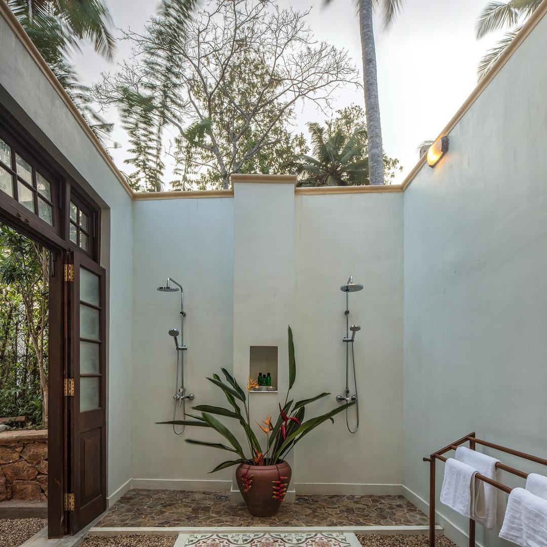 Outdoor shower with twin shower heads and tropical plant at Abiman, Dickwella