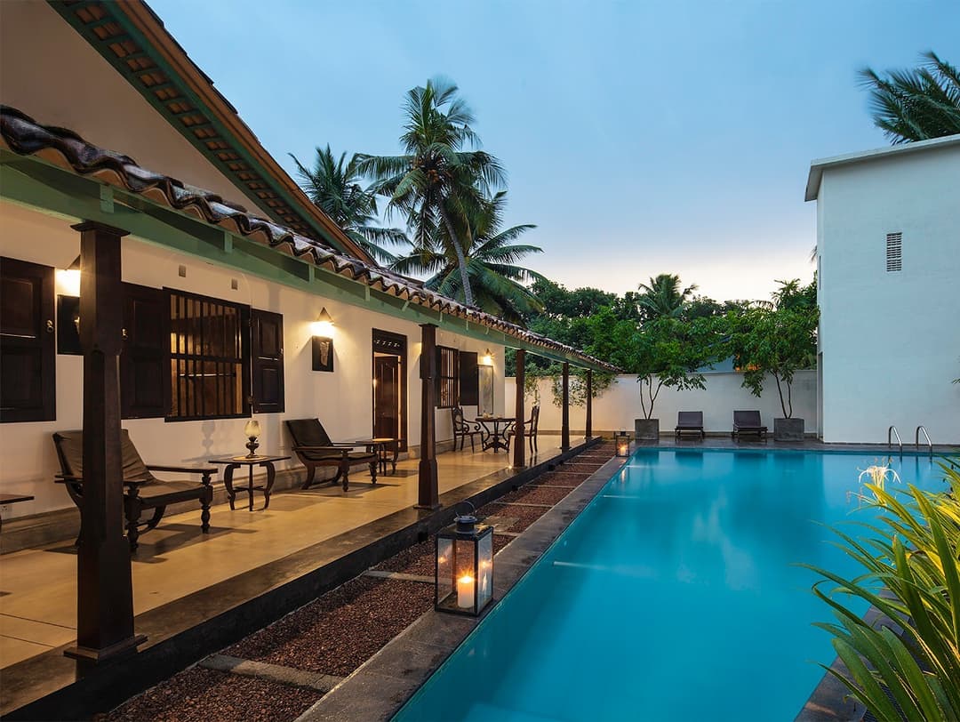 Pool with colonnade at dusk, Magalla Casa Galle