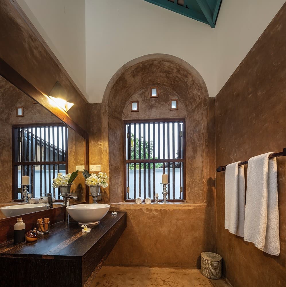 Bathroom with arched window and dark stone, Magalla Casa Galle