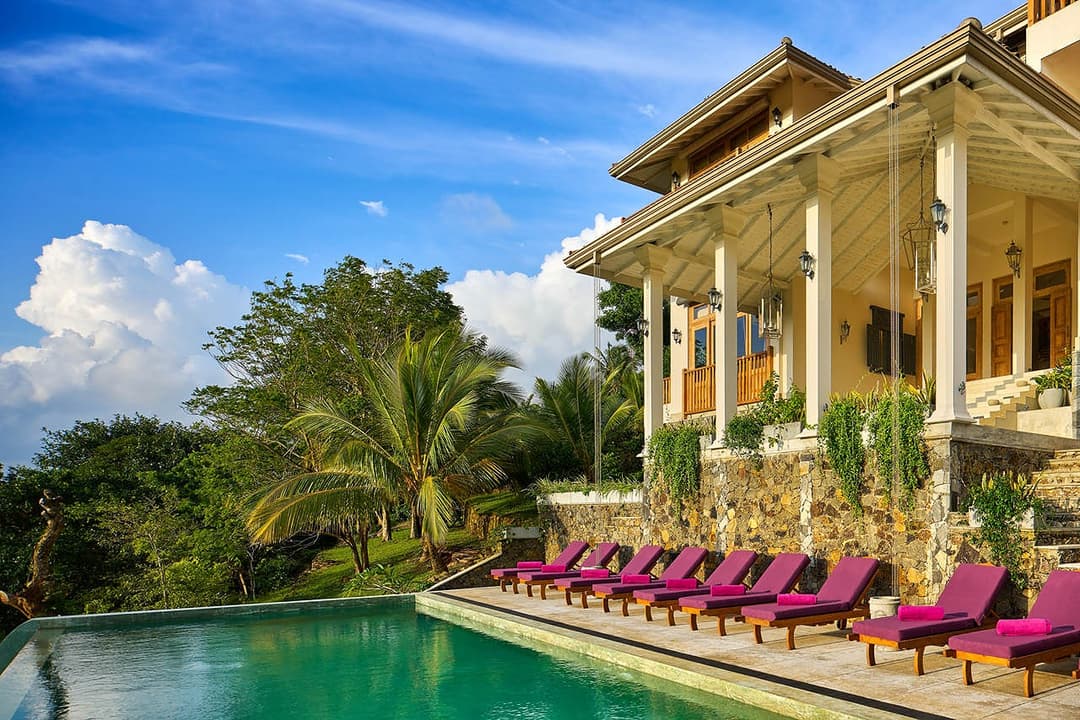 Pool deck with columns and palms, The Divine Villa Talpe