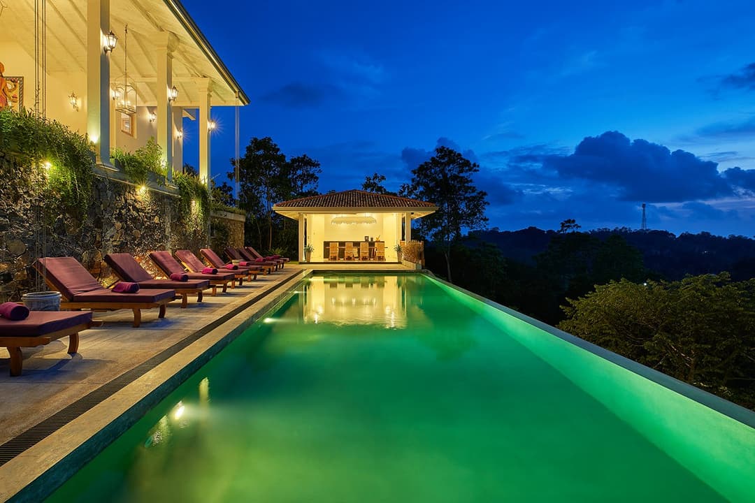 Pool deck lit at night angle, The Divine Villa Talpe