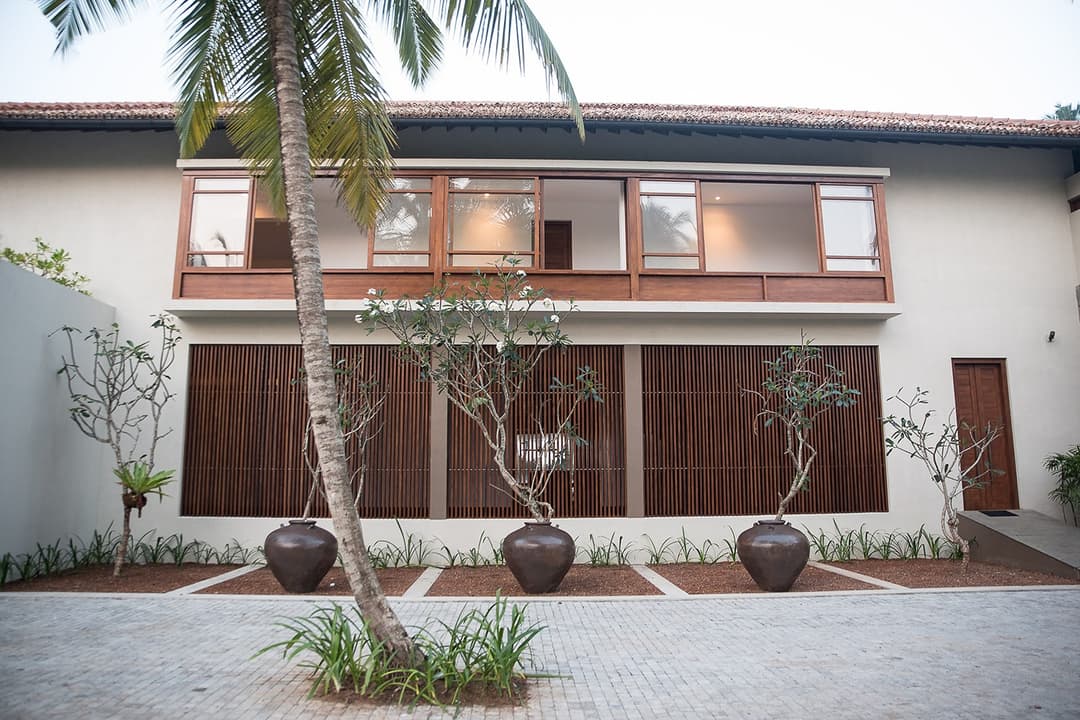 Villa exterior lit at night with palms, Villa by CC Wadduwa