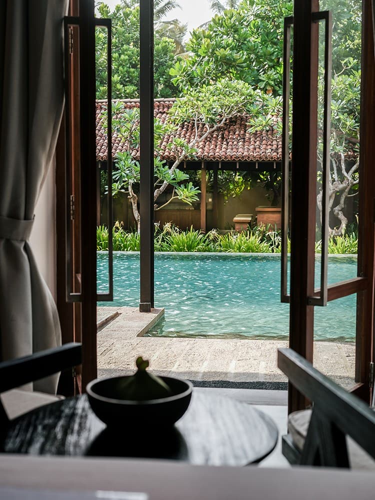 Indoor seating with pool view through window, Villa by CC