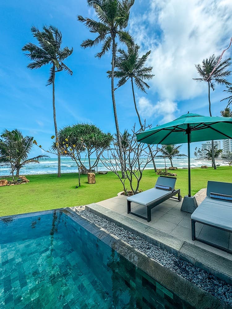 Pool with sun loungers palms and beach, Candella House Talpe