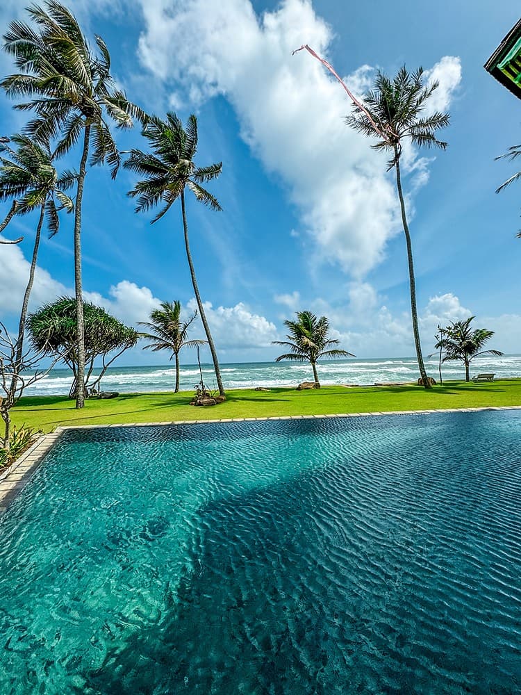Pool with palms and beach blue sky, Candella House Talpe