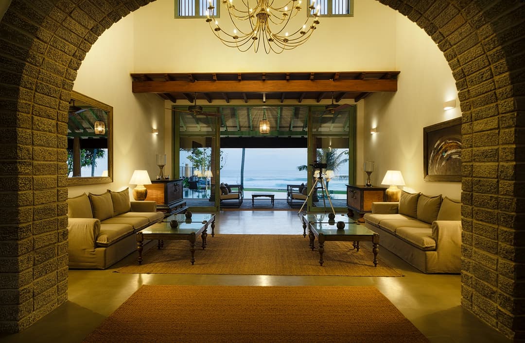 Living area with chandelier and arches, Candella House Talpe