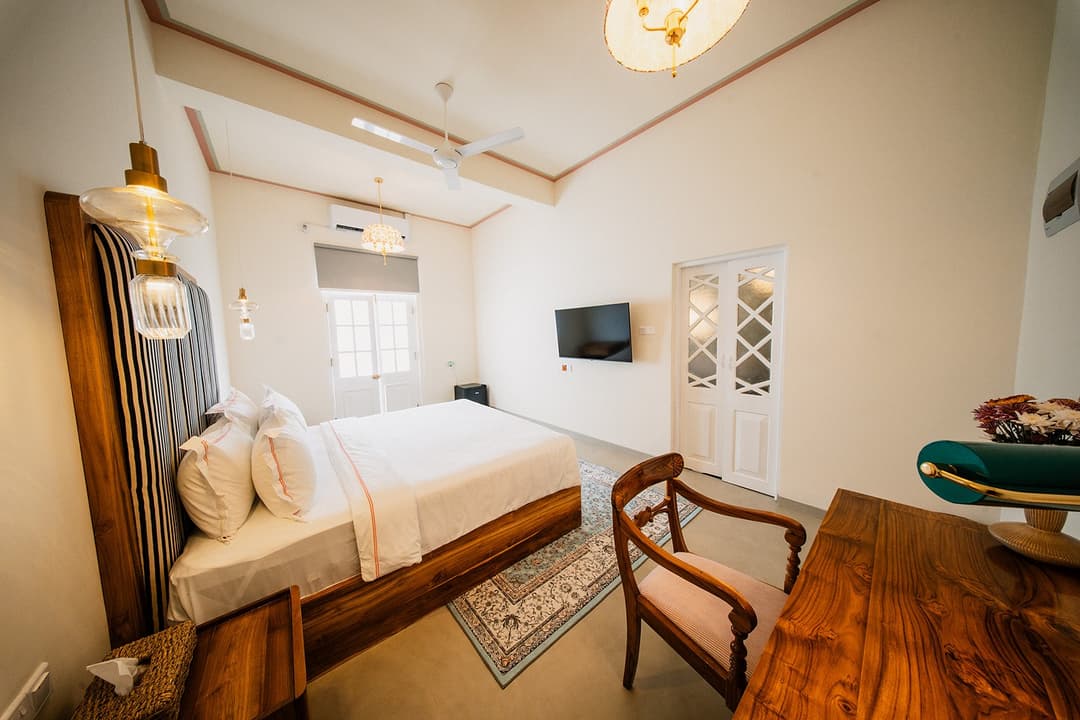 Dark room bed and chairs angle, Padmaraga Galle Fort