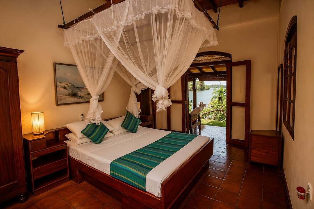 Koggala Lake bedroom with canopy bed and mosquito net