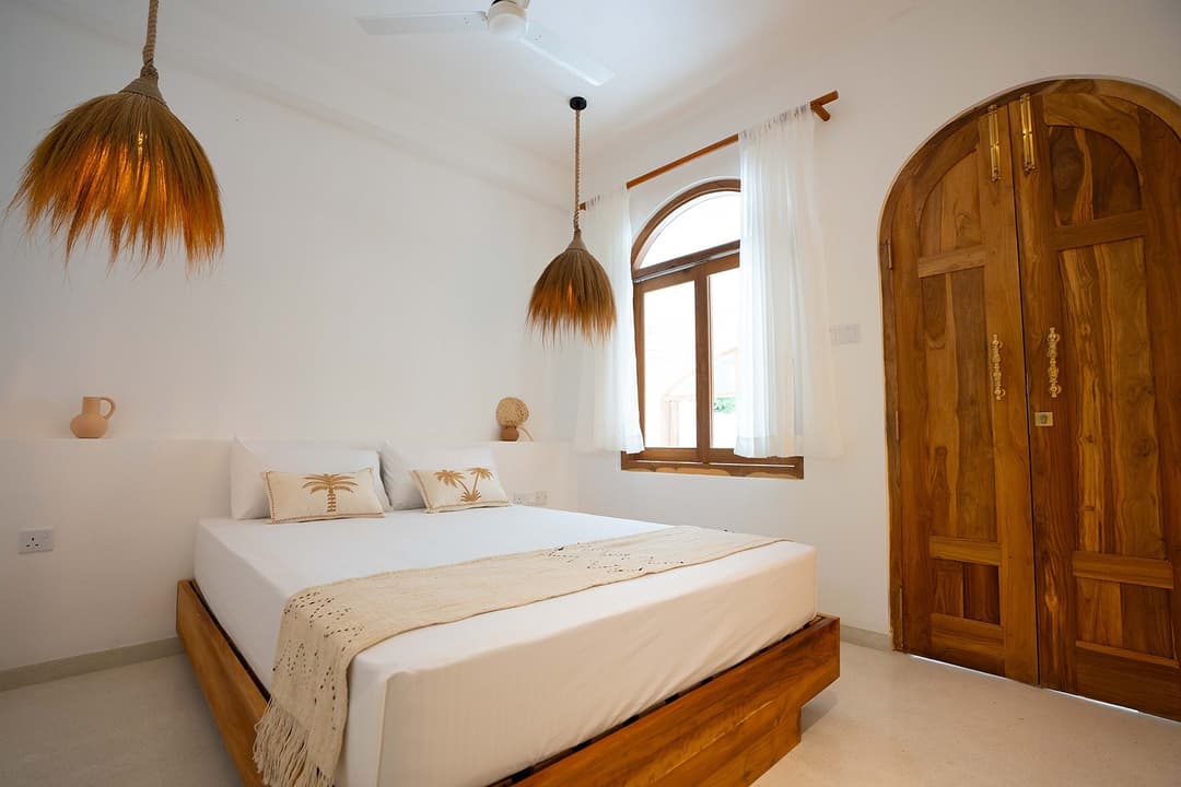 Ahangama bedroom with wood door and pendant light