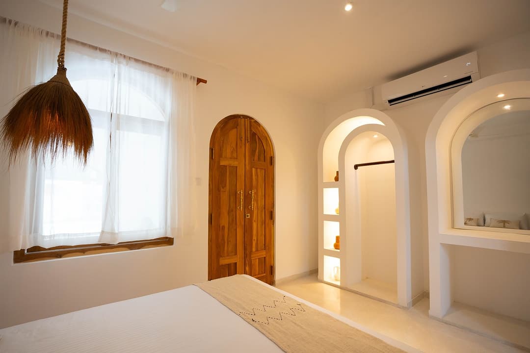 Ahangama bedroom with cream wall and arched doorway