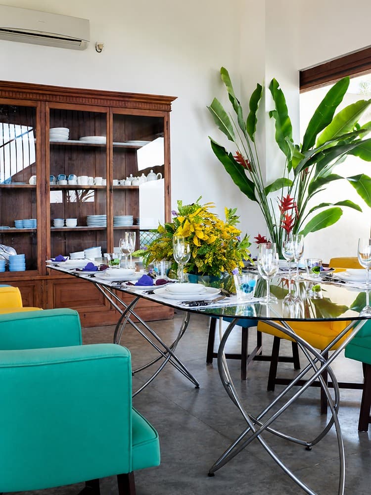 Mirissa dining room with glass table and teal chairs