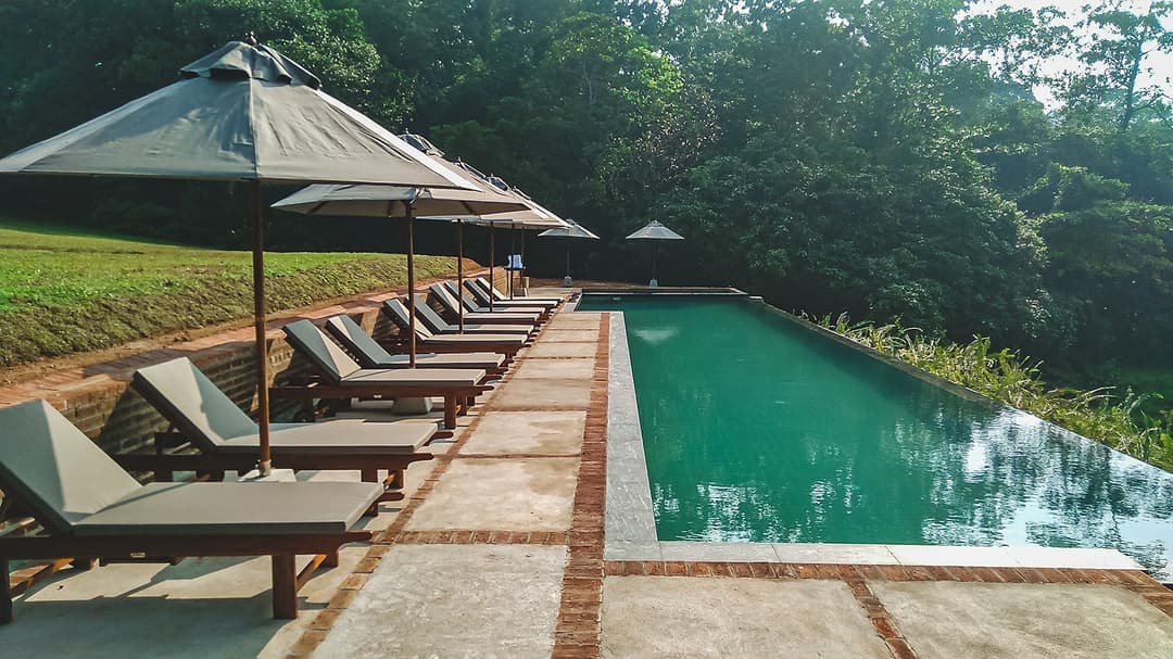 Lunuganga Bentota pool with loungers and garden view