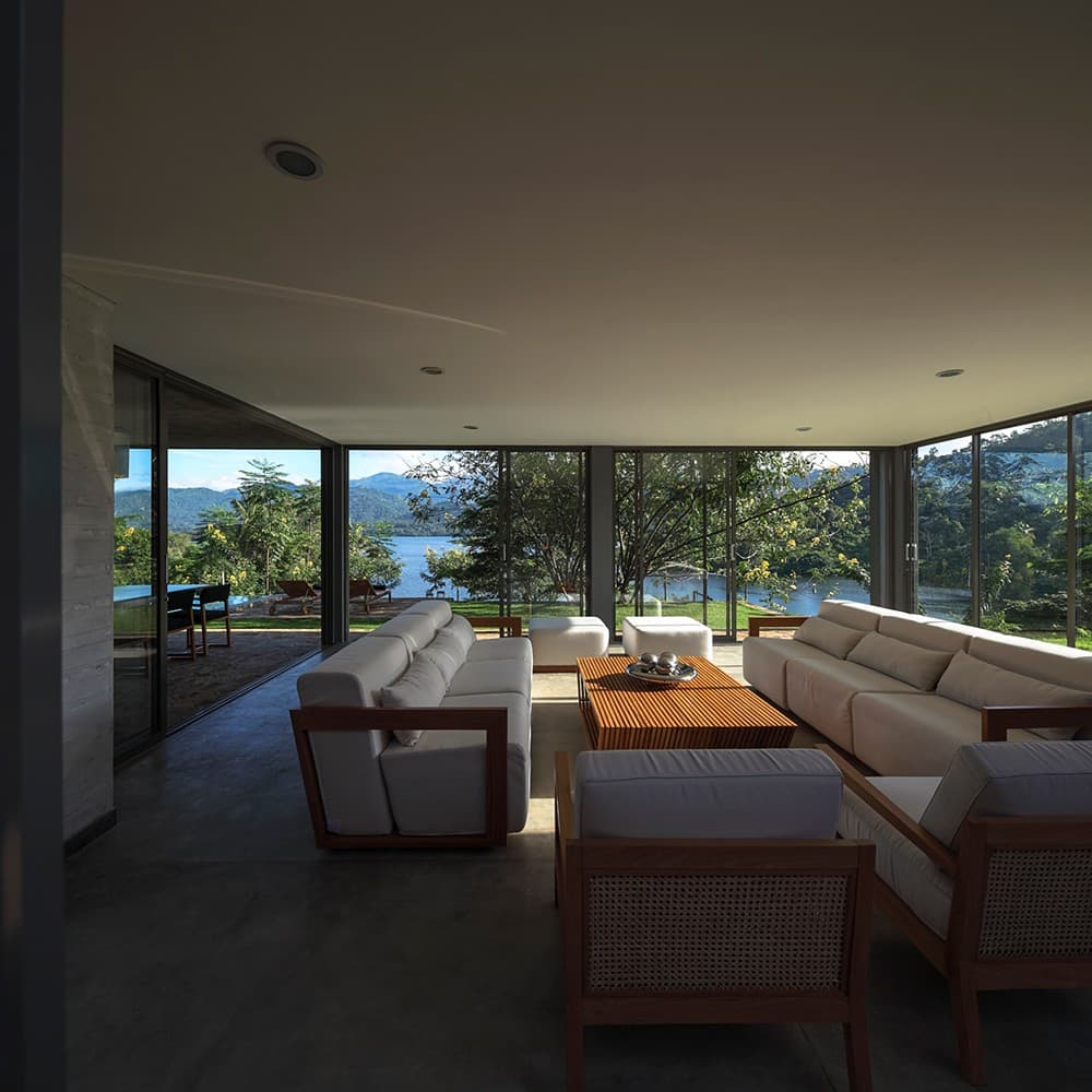Digana living room with glass walls and lake view