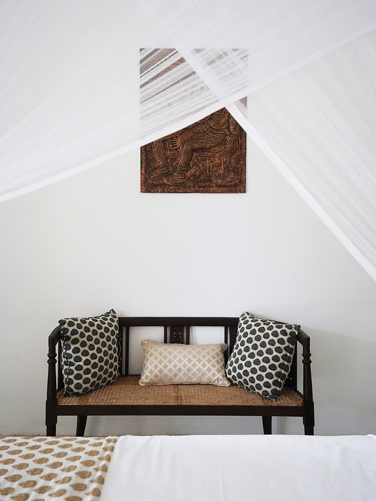 Ahangama bench with patterned pillows by bed