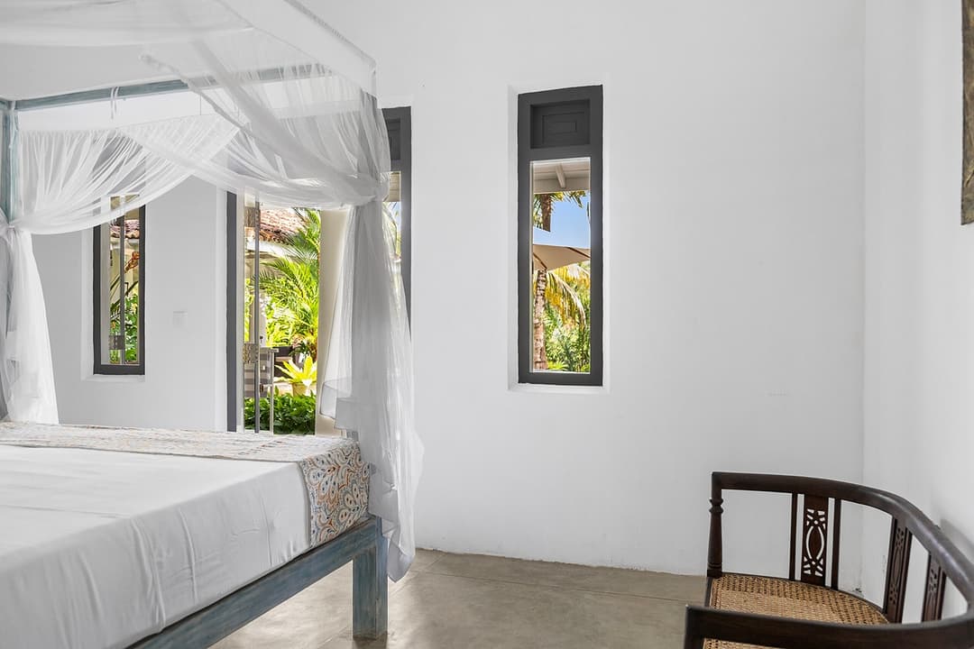 Ahangama bedroom with netted bed and windows