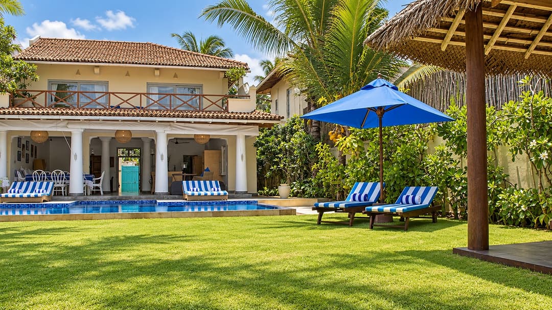 Villa Marisol pool with striped loungers and facade