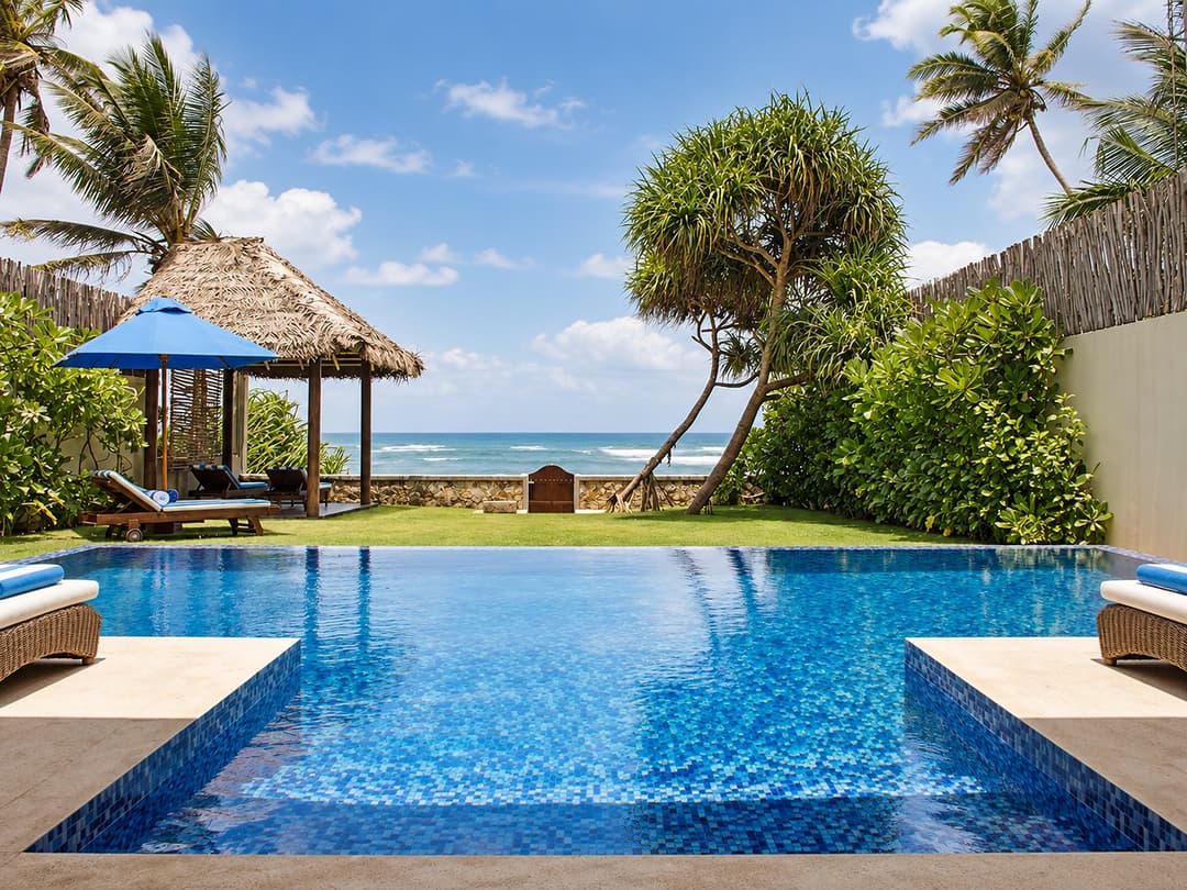 Villa Marisol pool with thatched pavilion near beach