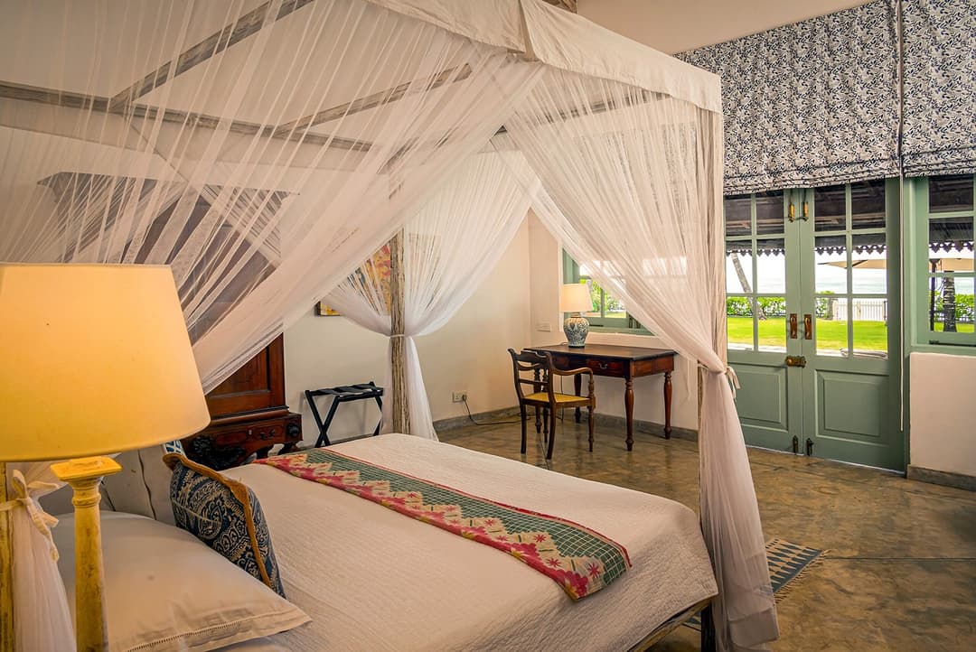 Habaraduwa bedroom with canopy bed and teal lamp