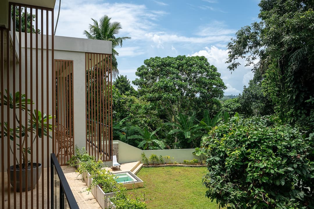 Kanda House Talpe exterior view with garden trees