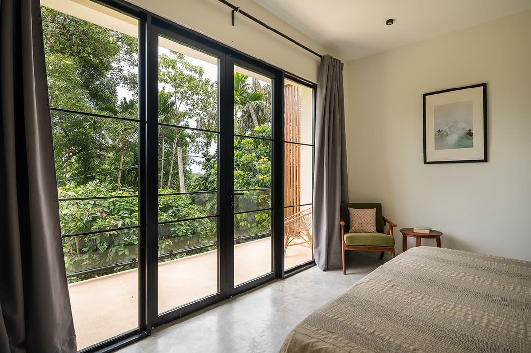 Talpe bedroom with glass doors and garden view